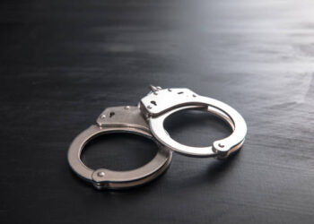 the black handcuffs on wooden background