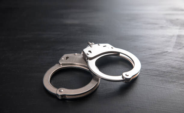 the black handcuffs on wooden background
