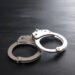 the black handcuffs on wooden background